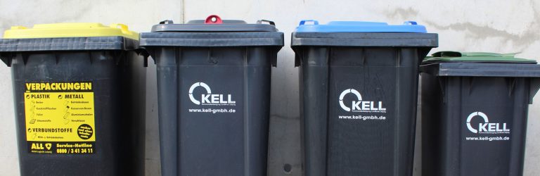 Mehrere Abfallbehälter mit unterschiedlichen Deckelfarben (z. B. Gelb, Blau, Grün) und KELL-Logo – Symbolbild für Entsorgungswege und Abfalltrennung.